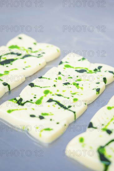 White chocolate bars with green splashes and patterns on a table, vegan chocolate production, Haselstaller Hof, Gechingen, Germany