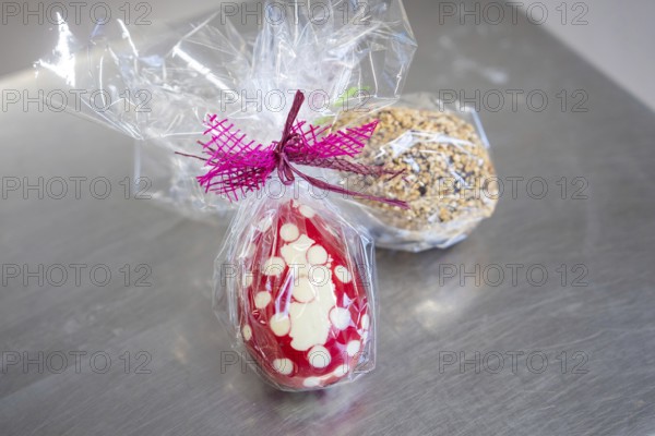 Two wrapped Easter eggs, one dotted in red and white with a bow, another covered with nuts, Easter production of regional products, Haselstaller Hof, Gechingen, Calw district, Germany