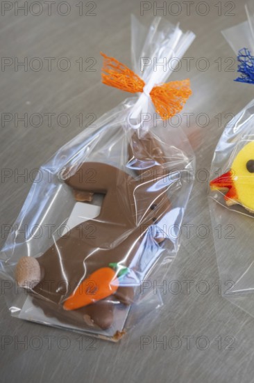 Brown chocolate rabbit cookie with carrot, wrapped in transparent film with orange ribbon, Easter production of regional products, Haselstaller Hof, Gechingen, Calw district, Germany