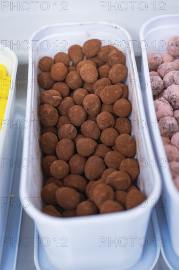 Container full of brown chocolate chocolates in a kitchen, chocolate quail eggs, Easter production, Haselstaller Hof, Gechingen, Germany