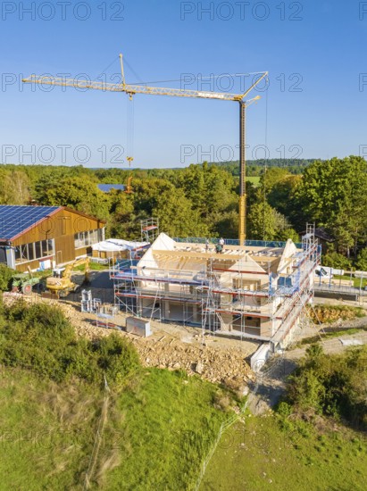 Building construction with scaffolding and crane in green surroundings, timber house construction, Gechingen, Germany