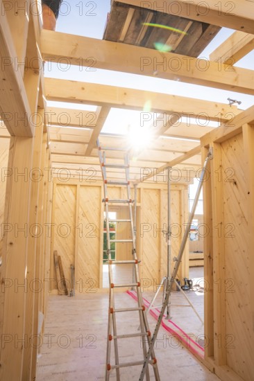 Interior of a wooden building panel with sun rays through ceiling opening, timber house building, Gechingen, Germany