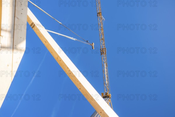 Construction elements in the foreground with a large crane, timber house construction, Gechingen, Germany