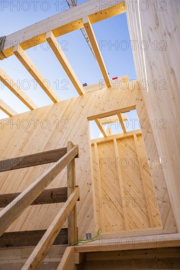Looking up through the wooden structure of a building on blue sky, timber house construction, Gechingen, Germany