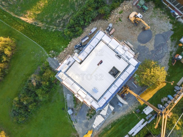Aerial view of a construction site with building foundation and crane in a green landscape, timber house construction, Gechingen, Germany