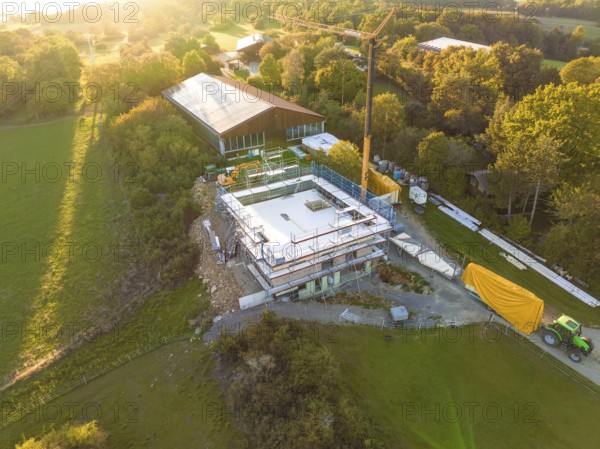 Construction site with a concrete foundation in a rural area, surrounded by green spaces, timber house construction, Gechingen, Germany