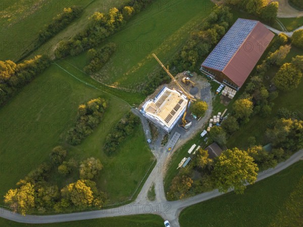 Aerial view of a construction site with a building under construction and solar roof in green landscape, timber house construction, Gechingen, Germany