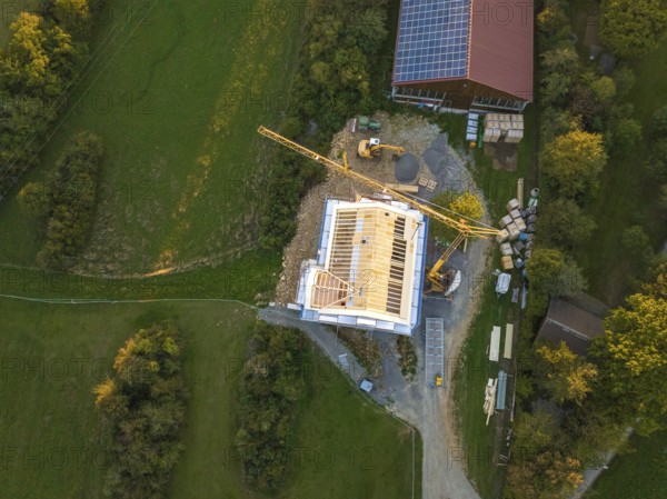 Aerial view of a construction site with a large construction building and solar system next door, timber house construction, Gechingen, Germany