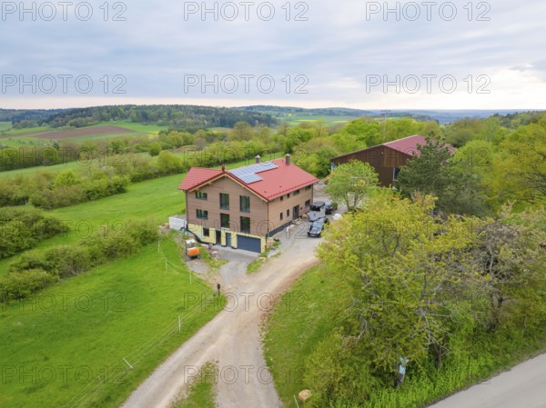 Farmhouse in green landscape under partly cloudy sky, timber house building, Gechingen, Germany