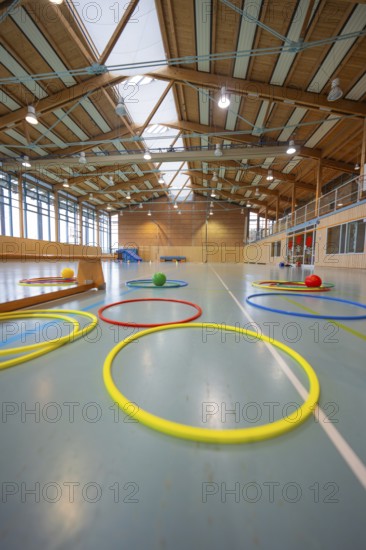 Colourful rings and balls on the floor in a large, well-lit sports hall, Schlehengäu Sporthalle Gechingen, Calw district, Germany