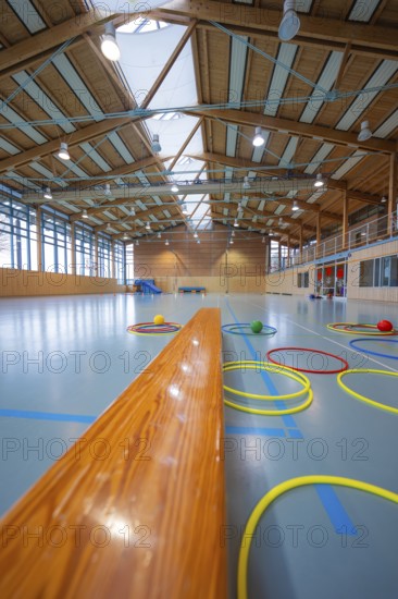 Tires lie on the floor of a gym next to a long wooden bench, Schlehengäu Sporthalle Gechingen, Calw district, Germany