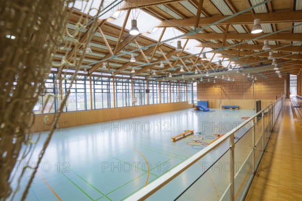 View of a spacious sports hall with basketball hoop and marked playing fields on the ground, Schlehengäu Sporthalle Gechingen, Calw district, Germany