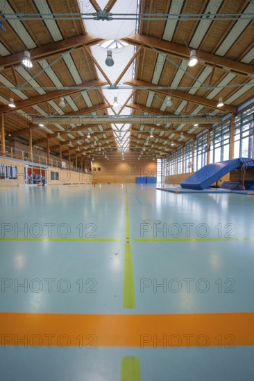 View of an empty sports hall with marked playing fields and glowing ceiling lamps, Schlehengäu Sporthalle Gechingen, Calw district, Germany
