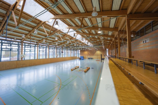 Spacious, bright sports hall with visible wooden roof and large window fronts along the walls, Schlehengäu sports hall Gechingen, Calw district, Germany