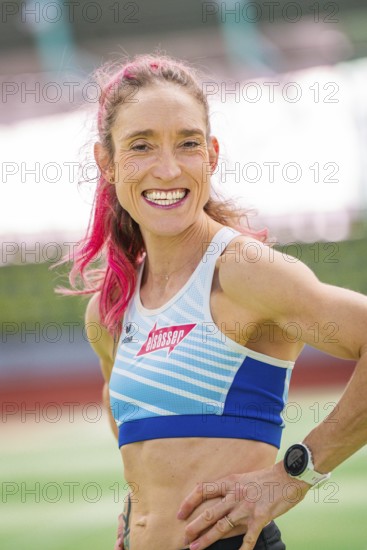 Woman smiling friendly with a wristwatch on in the stadium, middle distance runner Katharina Jaiser, Sindelfingen Glass Palace, Germany