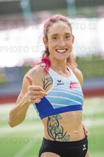Woman showing thumbs up and smiling with tattoos in stadium, middle distance runner Katharina Jaiser, Sindelfingen Glass Palace, Germany