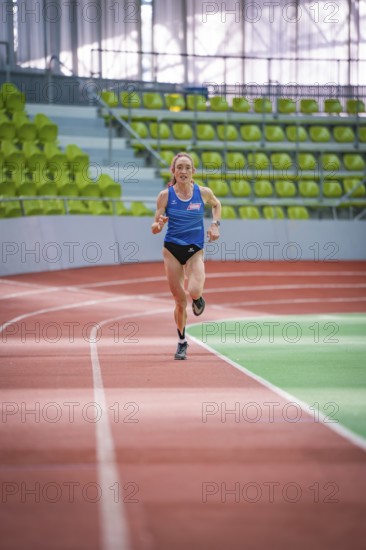 Woman sprinting straight ahead on a red track in the stadium, middle distance runner Katharina Jaiser, Sindelfingen Glass Palace, Germany