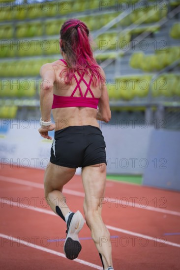 Determined woman running on a running track in a modern hall, middle distance runner Katharina Jaiser, Sindelfingen Glass Palace, Germany