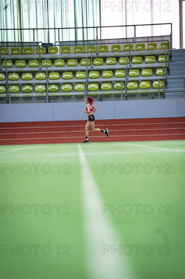 Female athlete running alone on an extensive track in a hall, middle distance runner Katharina Jaiser, Sindelfingen Glass Palace, Germany