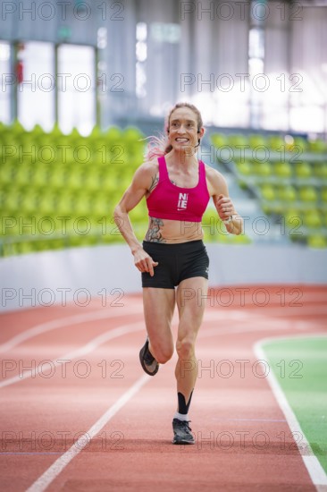 Sportswoman smiles and shows joy while running on an indoor track, middle distance runner Katharina Jaiser, Glaspalast Sindelfingen, Germany