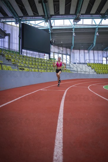Woman running on a red indoor track in a stadium, middle distance runner Katharina Jaiser, Sindelfingen Glass Palace, Germany