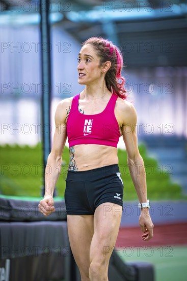 Woman wearing sporty clothes indoors showing determination against green background, middle distance runner Katharina Jaiser, Sindelfingen Glass Palace, Germany