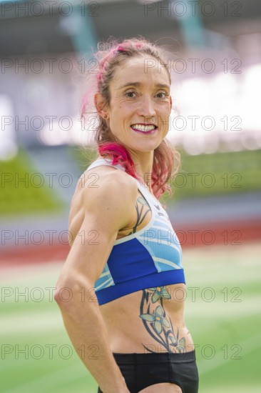 Sportswoman with blue sports outfit and tattoo in stadium, smiling with pink hair, middle distance runner Katharina Jaiser, Sindelfingen Glass Palace, Germany