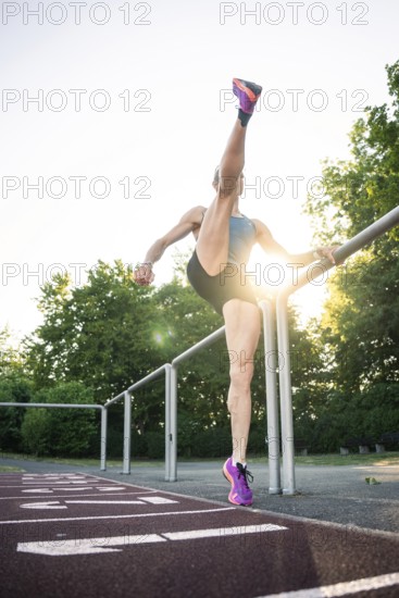 Woman steps high on a running track near a railing, middle distance runner Katharina Jaiser, Gechingen, Germany