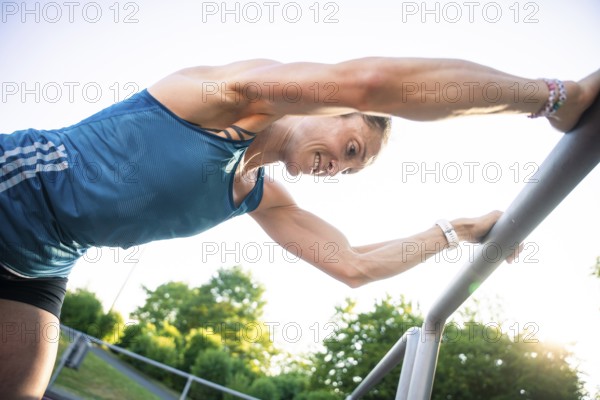 Woman bends over outdoor railings, concentrates on intensive training, middle distance runner Katharina Jaiser, Gechingen, Germany