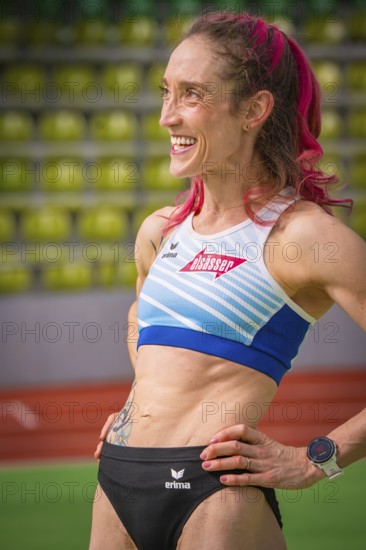 Smiling sportswoman with pink hair and tattoo, looks determined in the stadium, middle distance runner Katharina Jaiser, Gechingen, Germany