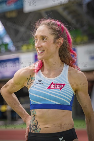 Smiling sportswoman with pink hair and blue sportswear in stadium, middle distance runner Katharina Jaiser, Gechingen, Germany
