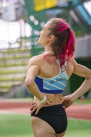 Female athlete with pink hair in the stadium, looking up. Determined atmosphere, middle distance runner Katharina Jaiser, Gechingen, Germany