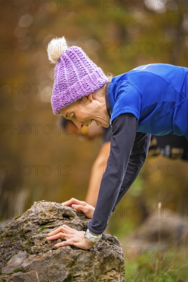 Woman in sporty pose on a rock surrounded by autumnal nature, middle distance runner Katharina Jaiser, Gechingen, Germany