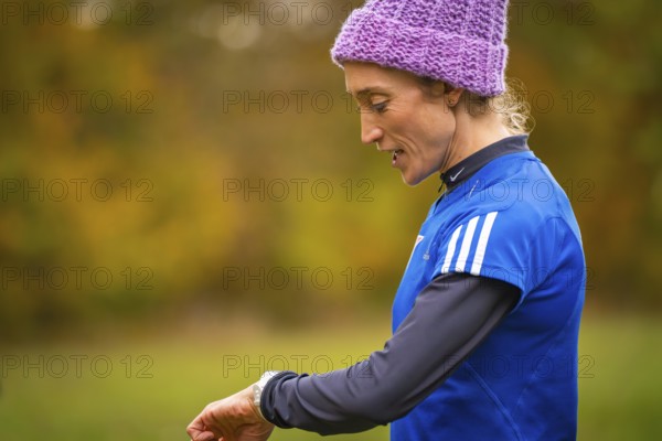 Woman wearing blue sportswear wearing purple cap in autumn setting, middle distance runner Katharina Jaiser, Gechingen, Germany