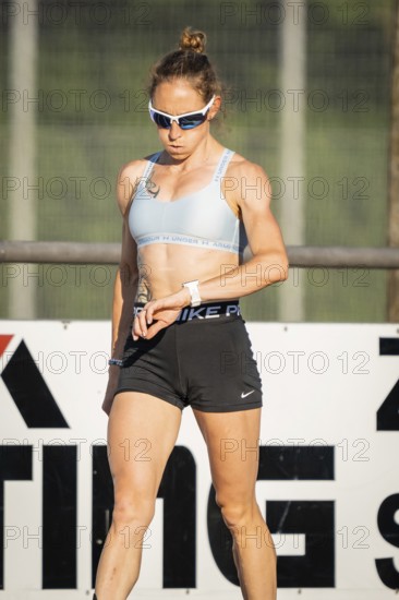 Athlete checks her watch on the sports field, focused and prepared, middle distance runner Katharina Jaiser, Gechingen, Germany