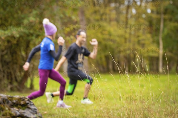 Two people running through an autumnal landscape, middle distance runner Katharina Jaiser, Gechingen, Germany