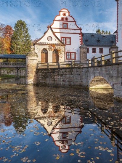 Kochberg Castle in autumn with bridge and reflection, colorful leaves in the castle moat, Großkochberg near Rudolstadt, Thuringia, Germany