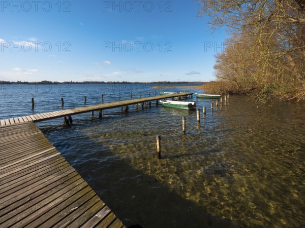 Jetty with rowing boats at Schaalsee in autumn, Schaalsee Biosphere Reserve, Mecklenburg-Western Pomerania Germany