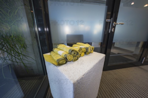 Yellow rolled up fabrics on a concrete pedestal in an office environment, Gechingen Town Hall, Calw district, Germany