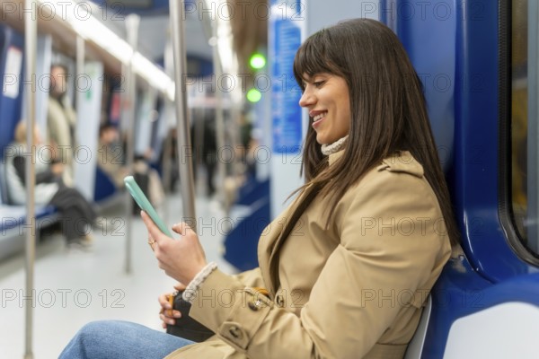 Young woman smiling and using her smartphone while commuting on a subway train, connecting with others or managing daily tasks during her urban journey