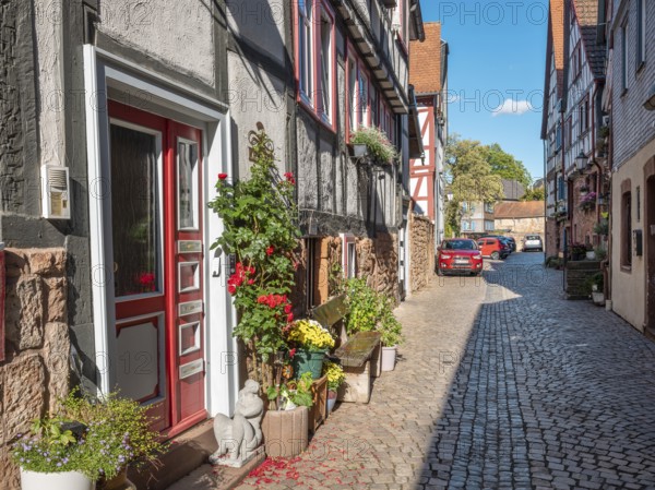 Narrow alley with half-timbered houses and cobblestones in the historic old town of Büdingen, Hesse, Germany