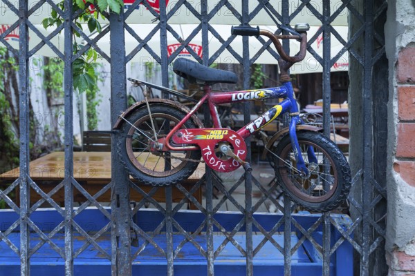 Old children's bicycle on an iron grid, Krakow, Poland