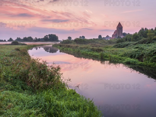 Tribsee with St. Thomas church on the river Trebel at dawn, North German brick Gothic, Peenetal river landscape nature park, Mecklenburg-Western Pomerania, Germany