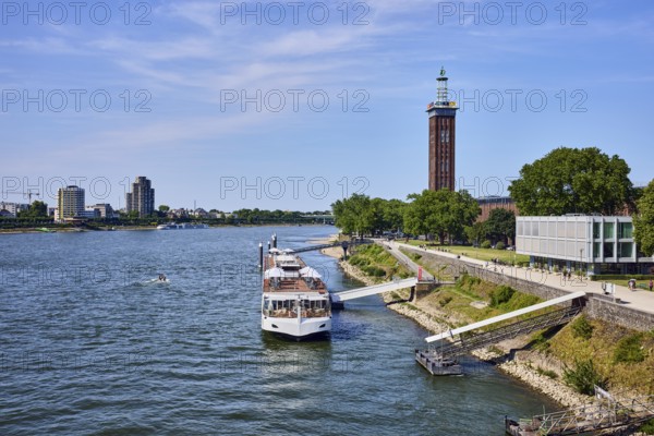 Rhine river, Rheinhallen exhibition halls, brick architecture, exhibition tower, general architecture, high-rise buildings, waterfront, river cruise ship Viking Einar, Viking Cruises, pier, Duckdalben, gangway, wharf, wharf, trees, bird's-eye view, blue sky, cirrus clouds, Kennedy shore, Cologne, district-free city, North Rhine-Westphalia, Germany