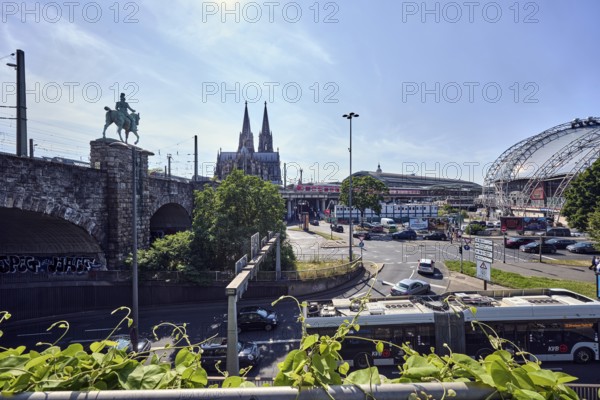 Cologne Cathedral, double tower, pedestrian and railway bridge, equestrian statue, lantern, main train station, roads, lanes, vehicles, lawn, trees, elevated perspective, back light, blue sky, cirrus clouds, federal road B51, Konrad-Adenauer-Ufer intersection with Trankgasse, Cologne, district-free city, North Rhine-Westphalia, Germany
