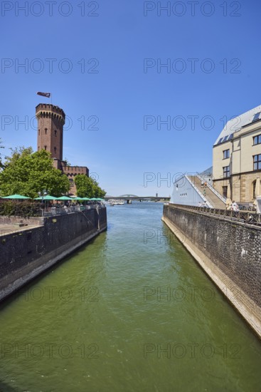 Rhine river, historic port, Rheinauhafen, quay wall, defense tower, Malakoff tower, building, outdoor area of a restaurant, trees, blue sky, cloudless, Cologne, district-free city, North Rhine-Westphalia, Germany
