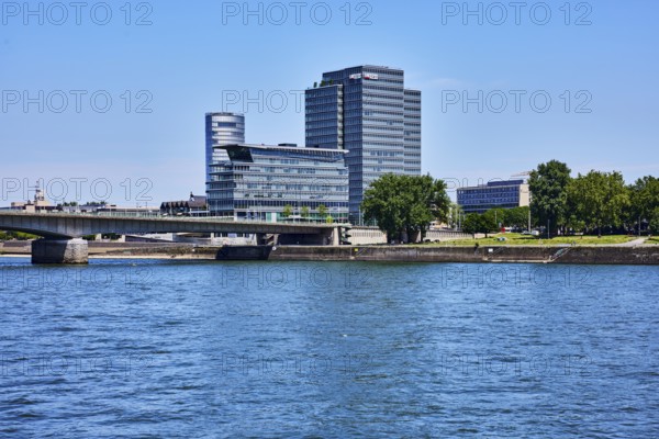 Rhine river, MaxCologne high-rise building, Lanxess, corporate headquarters, car bridge and footbridge Deutzer Brücke, trees, water surface with small waves, blue sky, cloudless, Cologne, district-free city, North Rhine-Westphalia, Germany