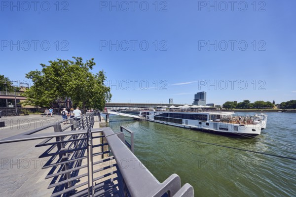 Rhine river, Viking Hlin river cruise ship, Viking Cruises, waterfront, metal railings, high-rise buildings, pedestrians as accessories, trees, blue sky, cirrus clouds, Leystapelwerft, Cologne, district-free city, North Rhine-Westphalia, Germany