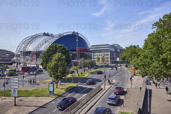 Large tent Musical Dome, general architecture, lantern, main station, roads, lanes, central island, pedestrian crossing, vehicles, parking lot, lawn, trees, elevated perspective, side light, blue sky, cirrus clouds, federal road B51, Konrad-Adenauer-Ufer intersection with Trankgasse, Cologne, district-free city, North Rhine-Westphalia, Germany
