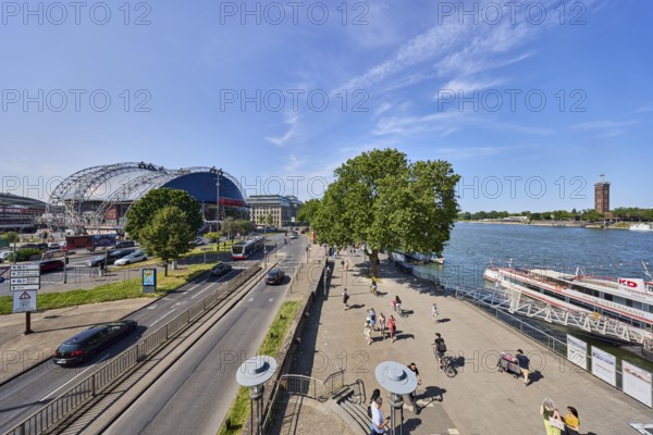Rhine river, large tent Musical Dome, exhibition tower, general architecture, footpath, waterfront, street, public bus, cars, wharf, gangway, excursion boats, pedestrians as accessories, lawn, trees, elevated perspective, blue sky, cirrus clouds, federal road B51, Konrad-Adenauer-Ufer, Cologne, district-free city, North Rhine-Westphalia, Germany